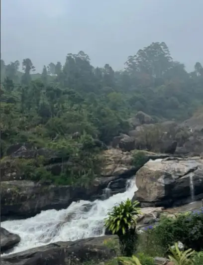 A forest waterfall cascading over rocks near Munnar, Kerala